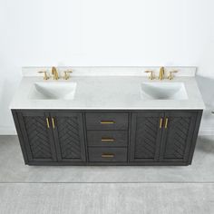 two white sinks sitting next to each other on top of a bathroom vanity with gold faucets