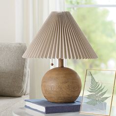 a wooden lamp sitting on top of a table next to a book and framed photograph