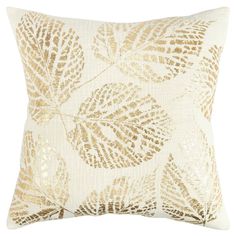 a gold and white pillow with leaves on it