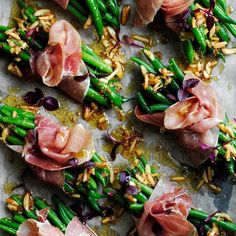 asparagus and prosciutto with almonds on a sheet of parchment paper