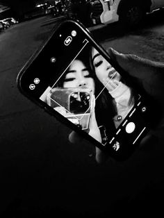 a person holding up a cell phone to take a selfie with the image of a woman's face