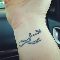 a wrist tattoo with an arrow and the word free on it