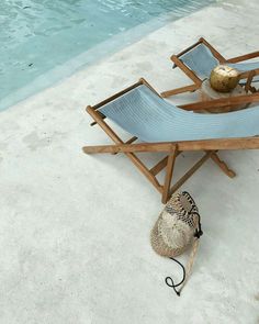 a hat is sitting on a chair next to a pool with a ball in it