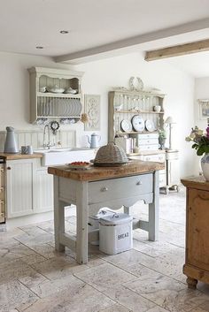 a kitchen with an island in the middle and lots of cupboards on it's sides