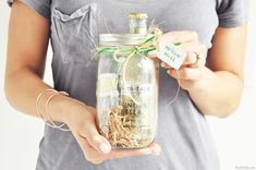 a person holding a jar with some stuff in it and a tag that says happy mother's day