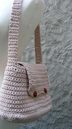 a crocheted handbag hanging on a white mannequin's head