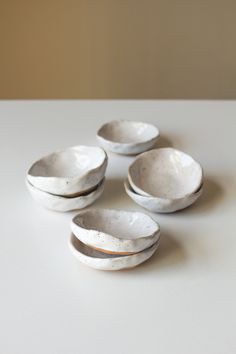 four white bowls sitting on top of a table