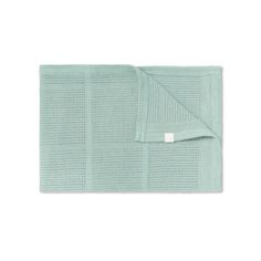 a light green towel folded on top of a white surface with a tag in the middle