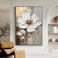 a white flower painting on a wall in a living room