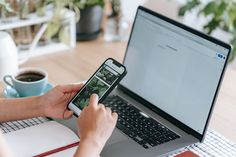 a person sitting at a table with a laptop and cell phone in front of them