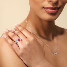 a woman wearing a diamond and ruby ring