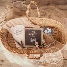 a wicker basket filled with personal items on top of a wooden floor next to a sign