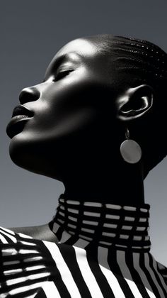 a woman with her eyes closed wearing black and white striped shirt, earrings and necklace