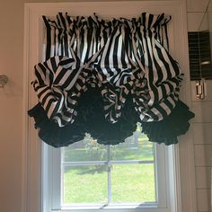 black and white ruffled valance hanging from the window