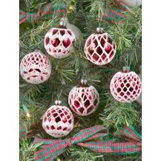 christmas ornaments hanging from a tree with red and green plaid ribbon on it's branches