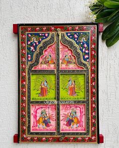 an ornately decorated wall hanging on the side of a building with flowers in it