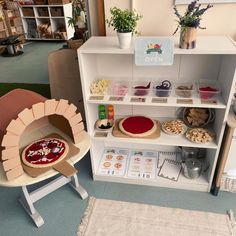 an open display case with pizzas and pies on it's shelves in a store