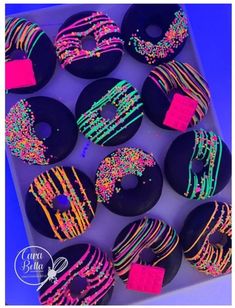 a box filled with lots of donuts covered in sprinkles and frosting