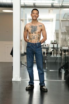 a man with tattoos standing in an office