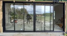 a man standing in front of a building with glass doors on it's side