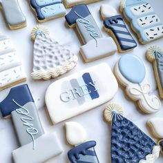 decorated cookies with blue and white frosting are arranged on a table top, next to the word grey