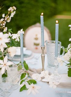 the table is set with white flowers and candles