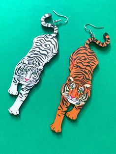 These prowling white and orange tiger earrings are the purffect addition to your look! Created from illustrations from my Feline Fierce print, these statement earrings are a must have for all big cat lovers.  Made from laser cut birch ply wood, these are super light weight and comfortable.  Sterling silver hooks.  Measurements: 110mm height x 34mm width Please note the grain and texture of the wood may vary a slightly from piece to piece.