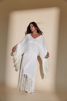 SOL FRINGE KAFTAN - OFF WHITE – Kadimah White Fringe V-neck Dress, Bohemian White V-neck Cover-up, White V-neck Dress With Fringe, Long Tassel Maxi Dress For Beach, White Maxi Dress With Tassels, Elegant White Kaftan For Festival, Long Maxi Dress With Tassels For Beach, Long Tassel Maxi Dress For Beach Cover-up, White Bohemian V-neck Cover-up