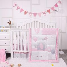 a pink and white baby crib bedding set with teddy bears on the wall