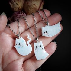 This listing is for 1 necklace of your choosing (while supplies last). Choose between A B C Handmade resin ghost kitty cabochon with a heart benzel attached on the back to create the necklace hoop. Silver tone chain and findings. Necklaces measures 10 inches from closed clasp to bottom of ghost kitty. The chain itself measures 18 inches long. Ghost kitty charm measures about 1 inch. Pet Ghost In A Jar Necklace, Handmade Silver Kawaii Necklaces, Kawaii Silver Handmade Necklaces, Kawaii Handmade Silver Necklaces, Handmade Silver Necklaces In Kawaii Style, Handmade Resin Jewelry For Halloween, Novelty White Sterling Silver Jewelry, White Sterling Silver Novelty Jewelry, Cute White Nickel-free Charm Necklaces