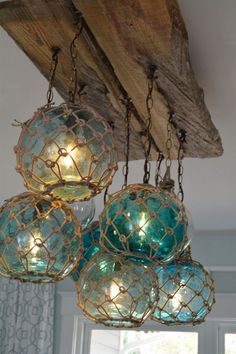 some blue glass balls hanging from a wooden beam