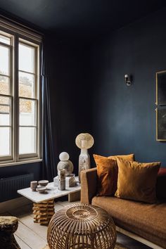 a living room filled with furniture and a large window in the corner, next to a coffee table