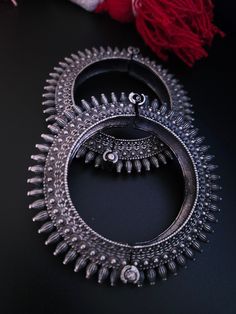 Steal everyone's attention with this stunning piece of jewellery.This kada/bracelet combines intricate detailing in a beautiful motif and contemporary design to help you make heads turn.The technique of oxidisation has been used to give a dull sheen and bring out the exquisite design.This is a bracelet that is openable and can be moulded to fit almost all sizes.Size :adjustable from 2 4 to 2.8 inches Ceremonial Metal Bangle Bracelet, Ornate Metal Chandbali Jewelry, Traditional Oxidized Bangle, Silver Bracelets With Tilla, Metal Bangle Bracelet With Intricate Design, Antique Silver Bangle Bracelets For Festivals, Elegant Jewelry With Motifs For Rituals, Festive Oxidized Metal Bracelets, Festive Oxidized Metal Bracelet