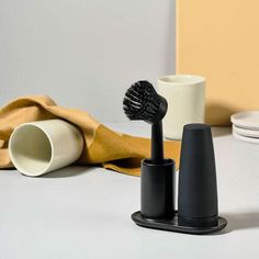 a black toothbrush sitting on top of a table next to a cup and saucer