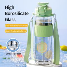 a glass water bottle with a green strap around it and the words, high borosilitate glass can be filled with hot water