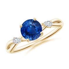 a yellow gold ring with an oval blue sapphire and two diamonds