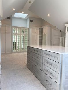 a large kitchen with an island in the middle of it and lots of cupboards