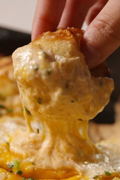 a close up of a person holding a spoon full of cheese and broccoli