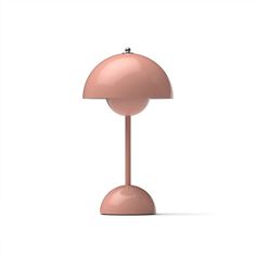 a pink table lamp sitting on top of a white surface