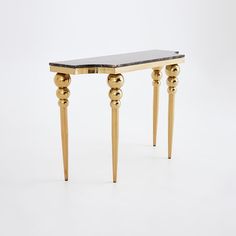 a table with two legs and a black marble top on the bottom, against a white background