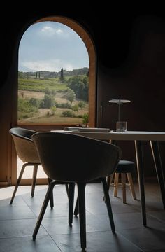 a table and chairs in front of an open window with a view of the countryside