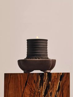 a candle that is sitting on top of a piece of wood