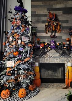 a decorated halloween tree in front of a fireplace