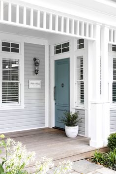 Hamptons style home entrance with powder blue front door, painted in Berger Winter Lake beneath crisp white fretwork on the verandah and a nickel and glass outdoor wall light. Hamptons Exterior, 1950s Cottage, Weatherboard Exterior, Weatherboard Cottage, Hamptons House Exterior, Hamptons Farmhouse, Hamptons Interior, Hamptons Cottage, Coastal Exterior