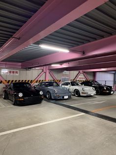 three cars parked in a parking garage with pink and yellow stripes on the ceiling,