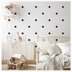 a bedroom with black polka dot decals on the wall and wooden furniture in front of it