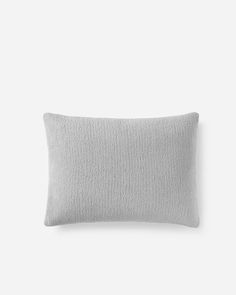 a gray pillow on a white wall