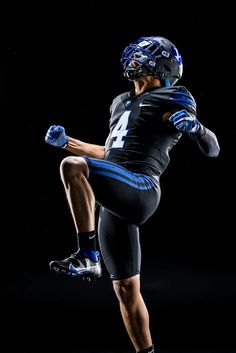 a football player is jumping in the air with his leg up and one hand on his hip