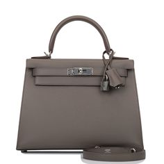 This Kelly, in the Sellier style, is in Etain epsom leather with palladium hardware and has tonal stitching, front flap, two straps with center toggle closure, clochette with lock and two keys a single rolled handle and removable shoulder strap. The interior is lined with Etain chevre leather and has one zip pocket with an Hermes engraved pull and two open pockets on the opposite side. Collection: ZOrigin: FranceCondition: Pristine; new or never (plastic on hardware)Accompanied by: Hermes box, H Hermes Kelly Sellier, Kelly Sellier, Hermes Box, Hermes Bags, Zip Pockets, Dust Bag, Top Handle Bag, Shoulder Strap, Fendi