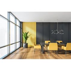 a dining room with wooden floors and yellow chairs